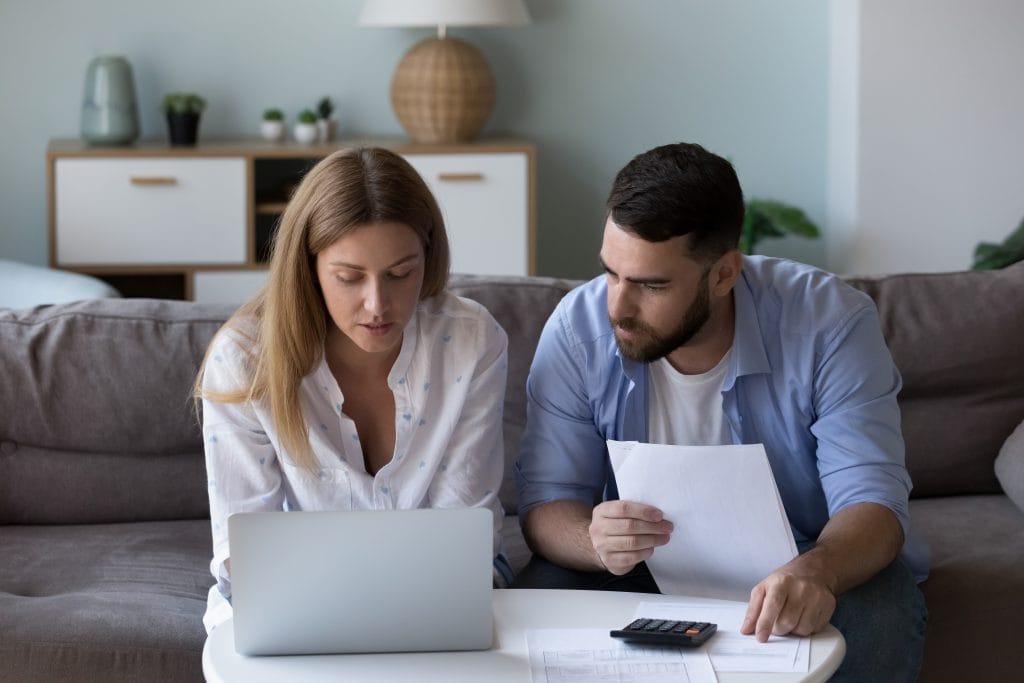 Serious focused millennial couple analyzing household budget - Winz Credit Debt Consolidation Loan