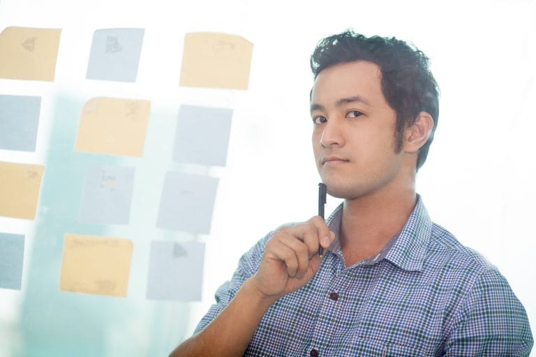 Thoughtful Asian manager at bulletin board - Winz Credit Thoughtful Asian manager at bulletin board